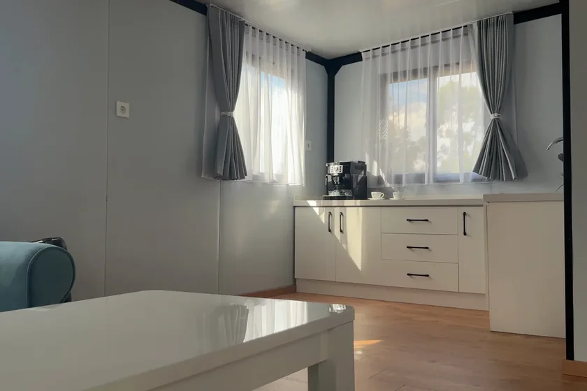 Obytný prostor domu s kuchyňskou linkou a dvěma okny